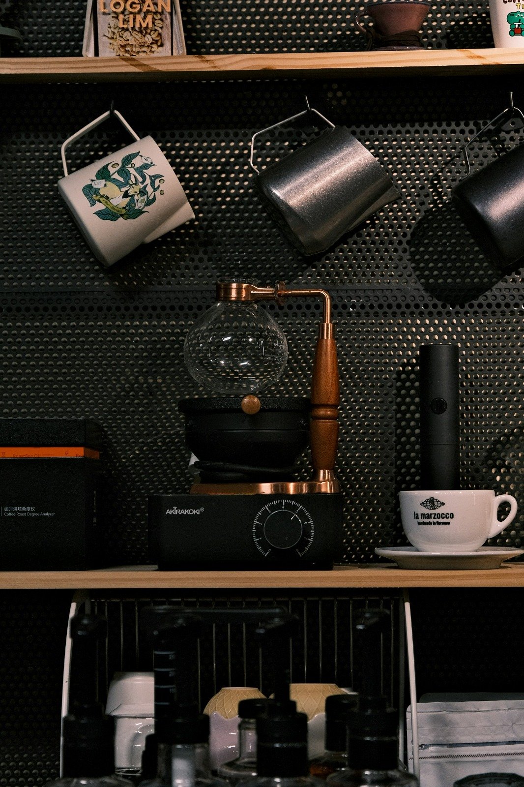 Coffee brewing equipment and mugs on a café shelf